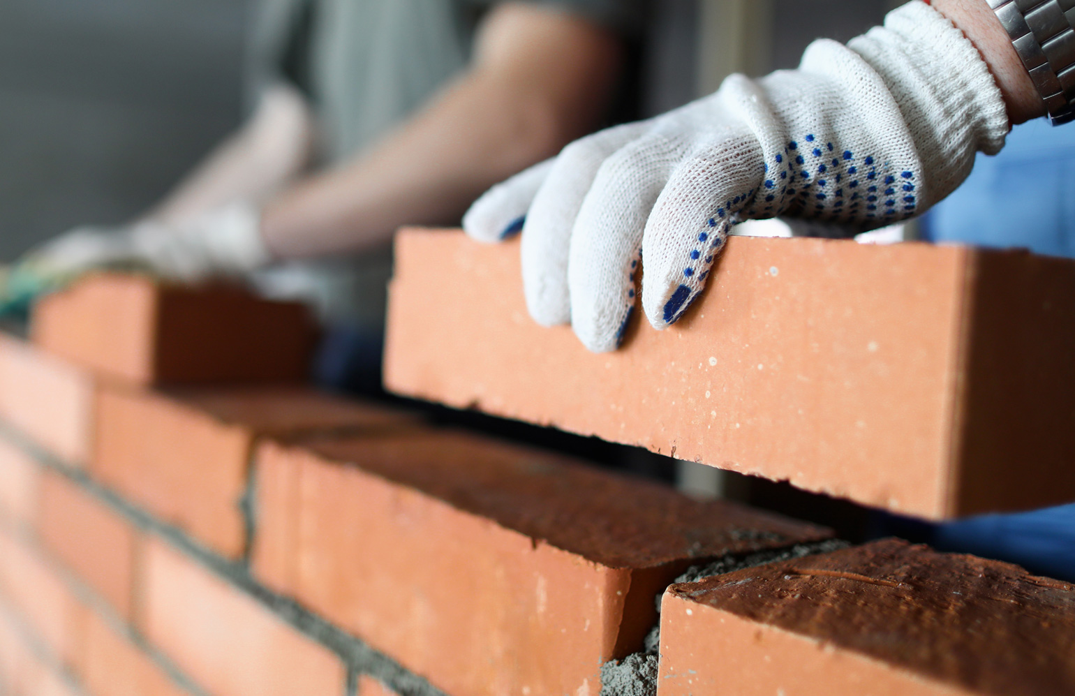 A small home builder does DIY on their home, building a brand new brick wall in their property