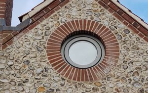 An example of an Apex BrickCutters circular brick window arch with brick soffits. The windows are set back from the brickwork, showing a check reveal detail.