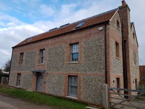 A Norfolk house using Apex BrickCutters Traditional FG2 brick arches with brick soffits as the windows are set back from the brickwork, showing a check reveal detail.