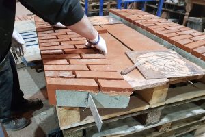 Construction of a pre-formed structural brick arch, a ready-made unit designed for quick installation, with brick slips set into a rigid framework for support.