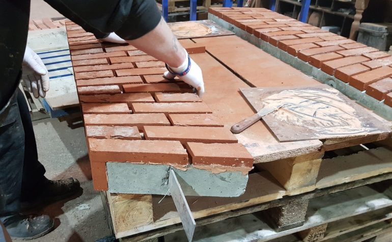 Construction of a pre-formed structural brick arch, a ready-made unit designed for quick installation, with brick slips set into a rigid framework for support.