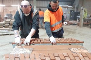 Apex BrickCutter employees applying brick slips to the front of structural arches.