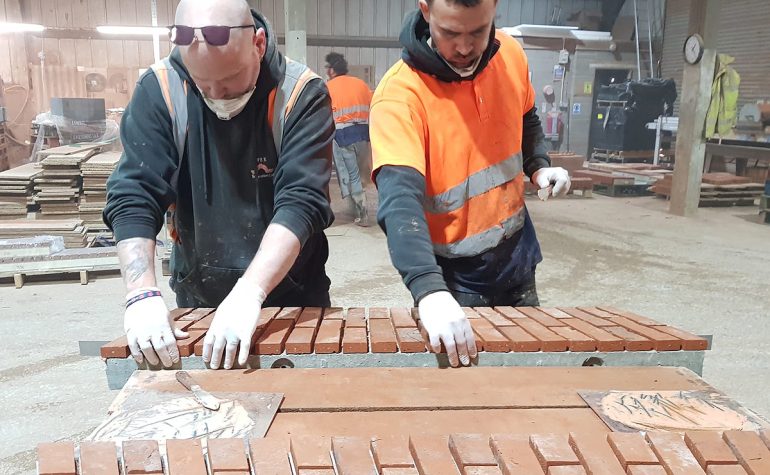 Apex BrickCutter employees applying brick slips to the front of structural arches.