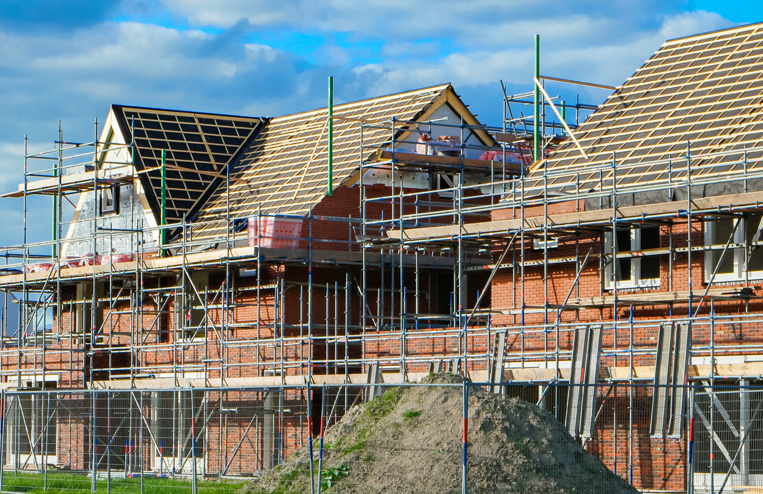 Multiple homes under construction by a major house builder with brickwork in progress on the houses