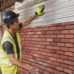 A workman on a building site uses a Brick Slip Cladding System to make slip installation faster, easier and more professional-looking